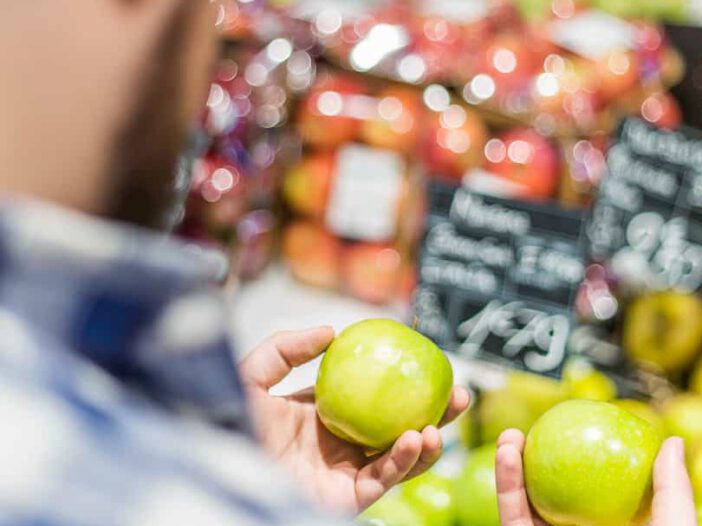 Hombre mirando dos manzanas